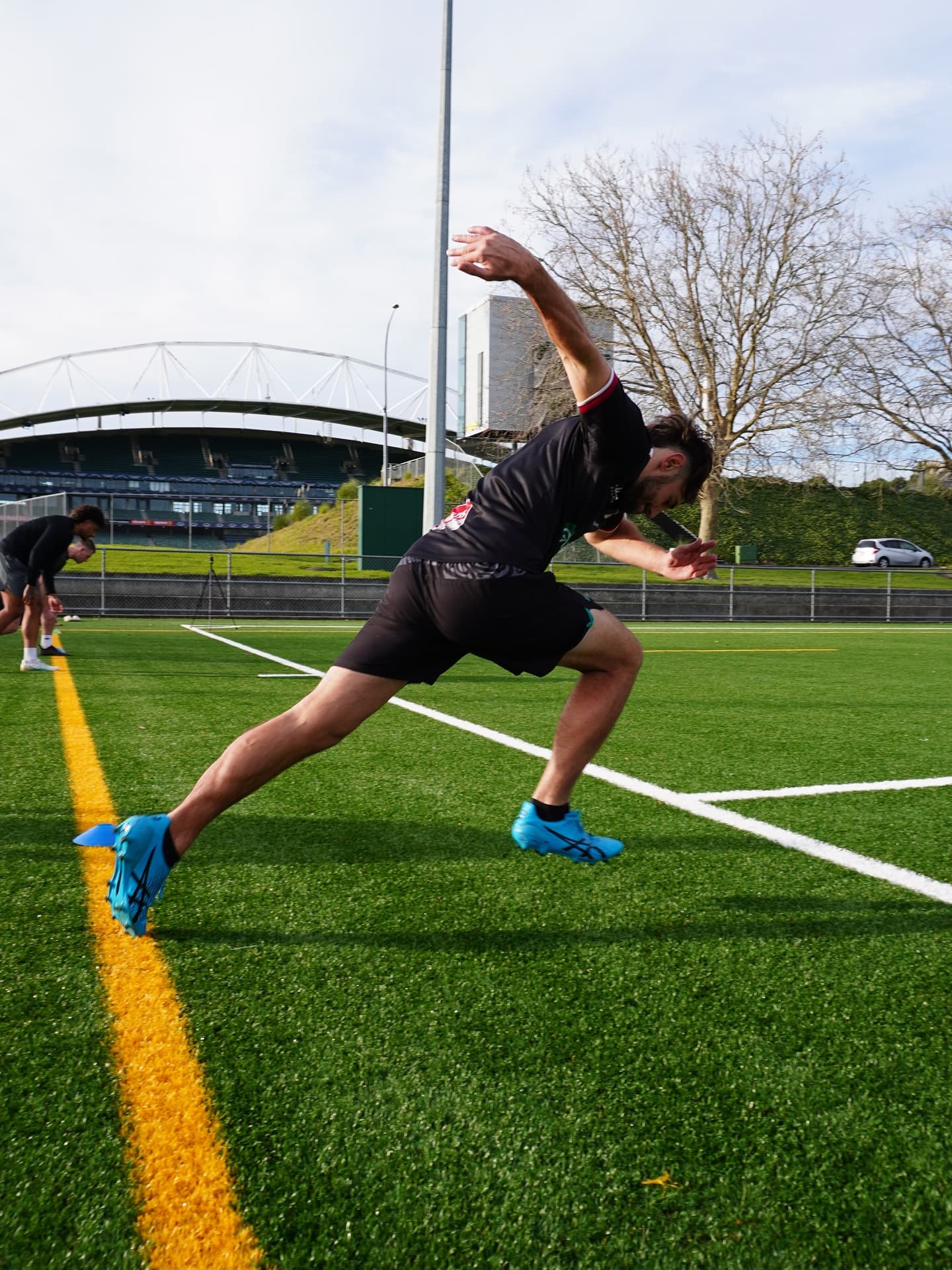 Athlete sprinting through VALD SmartSpeed laser timing gates at the ATL North Shore facility.